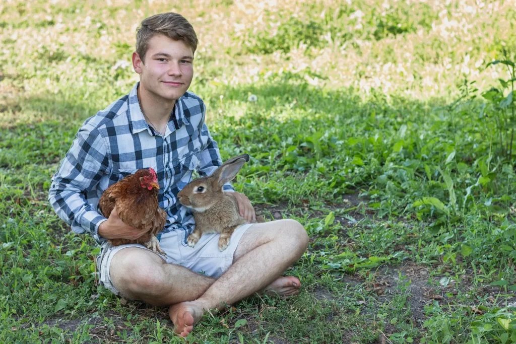 Jeune homme avec des animaux de la ferme
